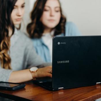  women sitting in front of laptop