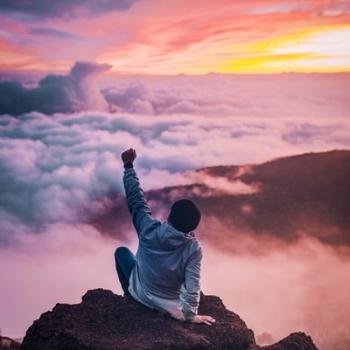 man sitting on mountain top