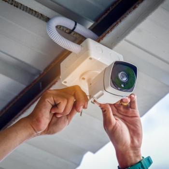 man installing a security camera